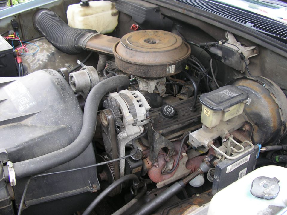 Engine bay with V8 engine, alternator, air filter housing, and brake fluid reservoir