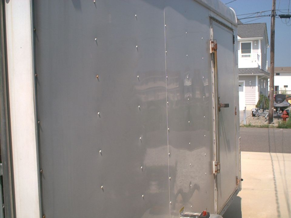 Gray trailer side with rivets and a door