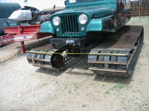 2000 Ford E350 - A modified Jeep with tracks instead of wheels is shown from the front, with a trailer attached.