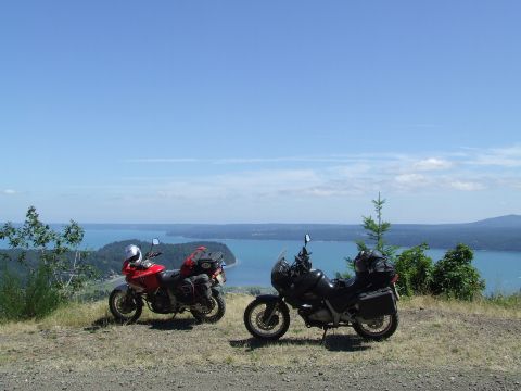 1997 BMW F650 - Two motorcycles are parked on a hill with a scenic view of a bay and islands.
