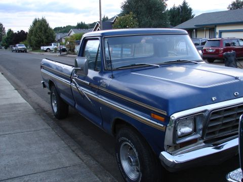 1996 Ford Bronco - This blue Ford F-150 pickup truck is parked on the side of a street in a neighborhood.