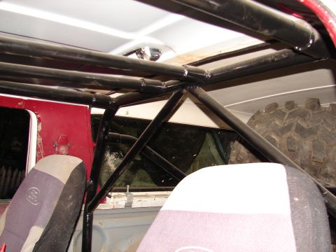 1996 Ford Bronco - Vehicle interior shows a custom roll cage and a spare tire mounted inside.