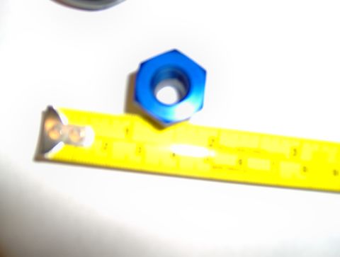 1978 Ford Bronco - A blue nut is shown next to a yellow measuring tape, indicating its size.