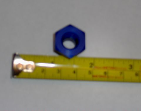 1978 Ford Bronco - A blue nut is shown next to a yellow tape measure, indicating its size.