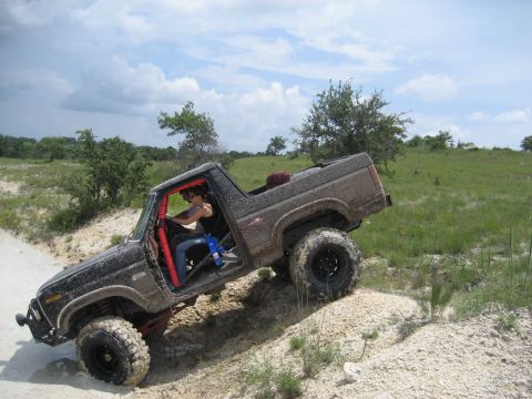 1986 Ford Bronco - Modified Ford Bronco climbing a dirt hill off-road.