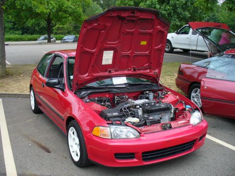 1991 Ford Probe - A red 1992 Honda Civic hatchback is parked with its hood open, revealing the engine bay.