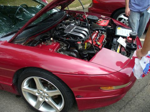1991 Ford Probe - A red 1991 Ford Probe is displayed with its hood open, revealing the engine and custom wheels.