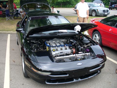 1991 Ford Probe - Front view of a black 1991 Ford Probe with its engine exposed, parked at an outdoor event.