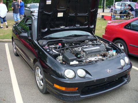 1991 Ford Probe - This black coupe, likely a 1994 model, is parked next to a red car with its hood open.
