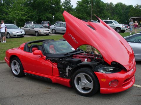 1991 Ford Probe - Red convertible with hood open, showing its engine. Other vehicles are parked in the background.