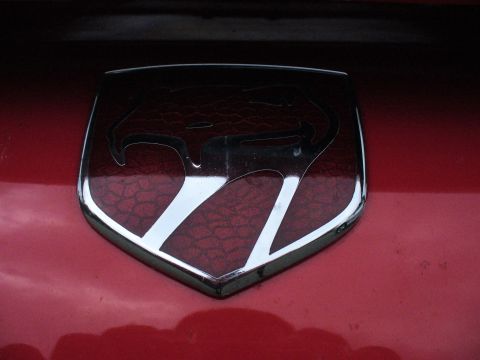 1991 Ford Probe - The iconic snake emblem of a Dodge Viper is shown on a red vehicle's body.