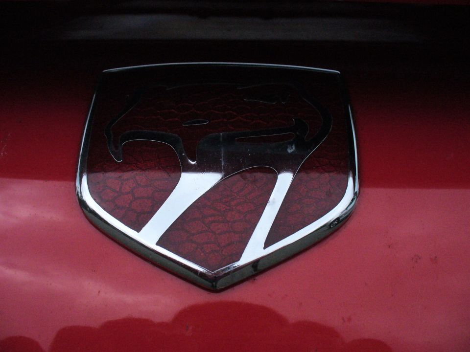 Close-up of a red car's Dodge Viper emblem