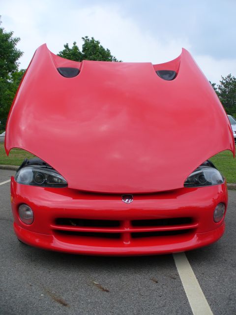 1991 Ford Probe - The front of a red sports car is visible with its hood open, revealing the headlights and grille.