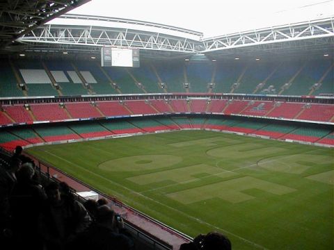 1968 Ford Mustang - Interior view of a stadium with seating in green and red, and the letters "UCL" mown into the grass field.