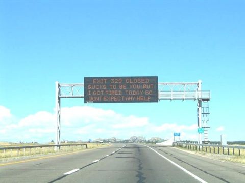 1968 Ford Mustang - A digital highway sign displays a message about a closed exit and the sign operator's recent firing.