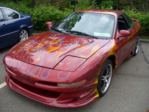1991 Ford Probe - This 1991 Ford Probe features a custom flame paint job and body kit, parked outdoors next to another vehicle.