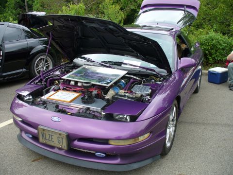 1991 Ford Probe - A purple 1991 Ford Probe is displayed with its hood and trunk open, revealing the engine bay and a glimpse of the interior.