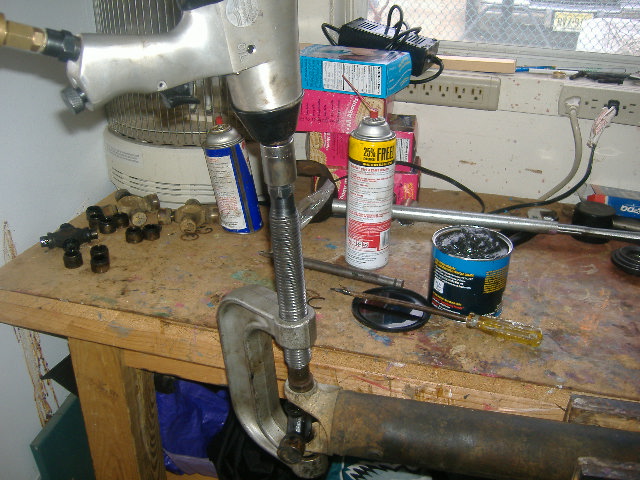 The ball joint tool in action.  Mine came with a manual that had a pic of a guy hold the driveshaft in one hand and a ratchet on top of the threaded end with the other.  Yeah right.  Unless the cups are too small and you super lubed them, there is no way on earth you are holding with one hand and turning with another.  After I ripped my bench vice off the bench (within the first ten minutes), I put it back on, fired up the tank and let the impact gun do the work.  Use grease, and go get some patience.