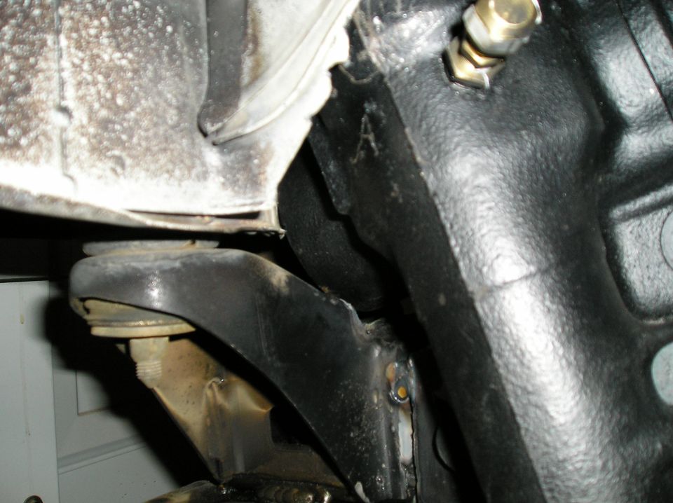Close-up under vehicle showing engine oil pan, frame, and mount bracket