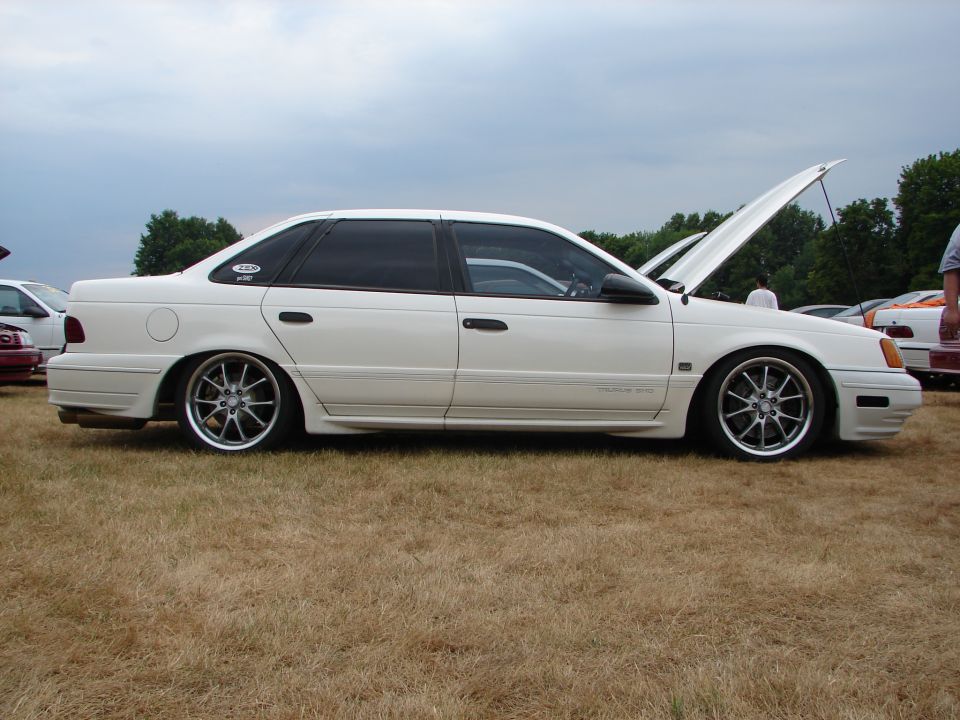 White 1993 Ford Taurus sedan, side view, lowered on aftermarket wheels