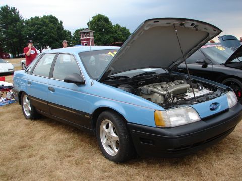 1993 Ford Taurus - Light blue 1993 Ford Taurus SHO at a car show, engine compartment exposed.