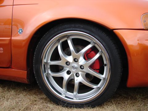 1993 Ford Taurus - The custom wheel and bright red brake caliper are visible on the orange vehicle.