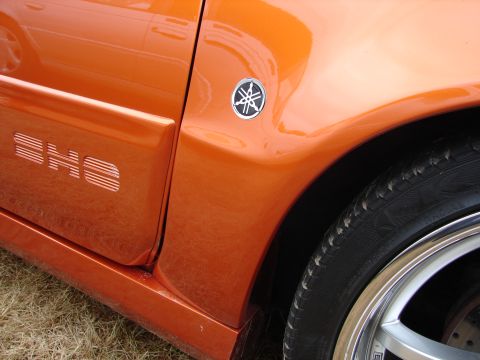 1993 Ford Taurus - Close-up of an orange car's side panel, showing the "SHO" designation and a Yamaha logo.
