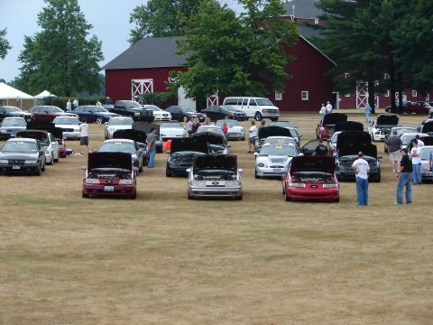 1993 Ford Taurus - A car show event is taking place outdoors with numerous vehicles displayed on a grassy field.