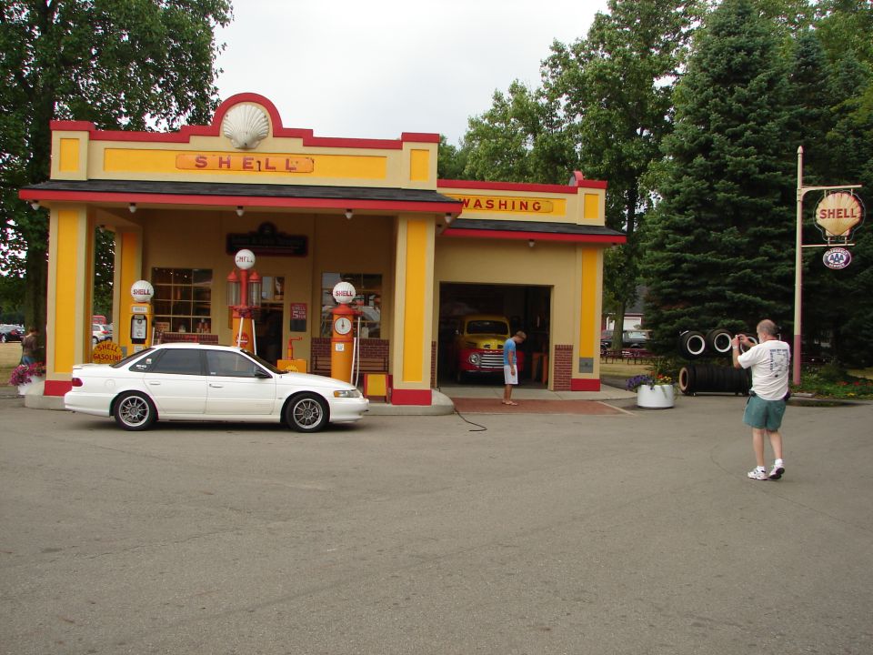 White 1993 Ford Taurus parked at vintage Shell gas station