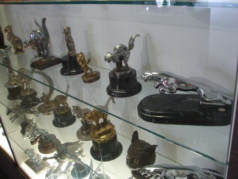 1993 Ford Taurus - A collection of car hood ornaments, primarily animal figures, are displayed inside a glass case.