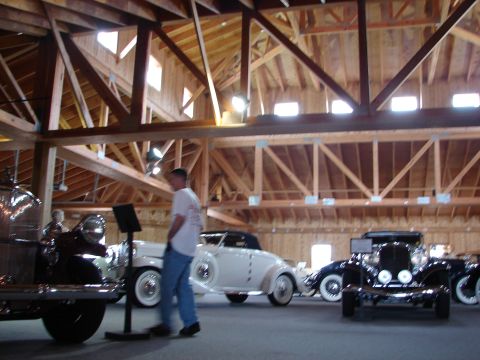 1993 Ford Taurus - A collection of classic automobiles are exhibited within a rustic wooden structure.