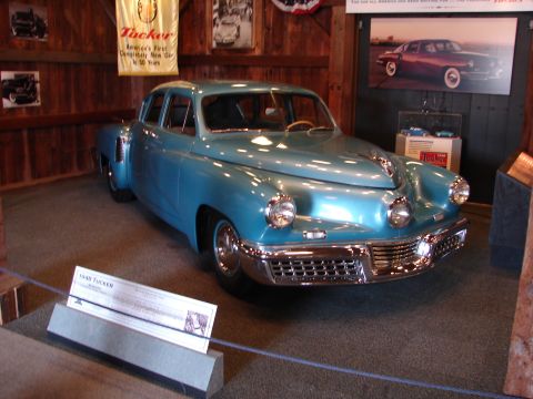 1993 Ford Taurus - A blue 1948 Tucker sedan is displayed indoors with historical signage and photographs.