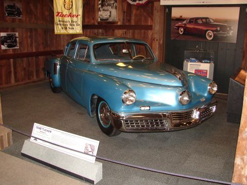 1993 Ford Taurus - A blue 1948 Tucker sedan is displayed indoors with a sign indicating its model year.