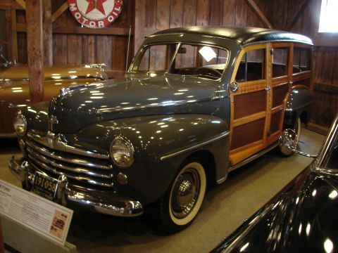 1993 Ford Taurus - This 1946 Ford woody wagon is displayed indoors, with another vehicle visible to the right.