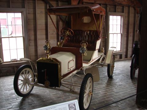 1993 Ford Taurus - This antique automobile features a white body with brown accents and brass lamps.