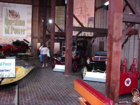 1993 Ford Taurus - A museum exhibit showcases several vintage automobiles and early gasoline pumps, with informational posters in the background.