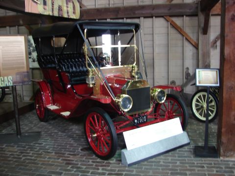 1993 Ford Taurus - This antique touring car is displayed indoors with informational signs nearby.