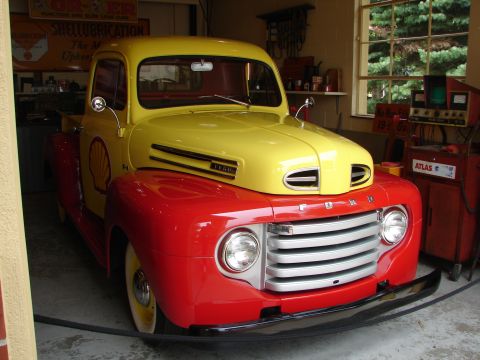 1993 Ford Taurus - A vintage red and yellow Ford F-Series truck, likely from the late 1940s, is parked indoors with Shell branding.