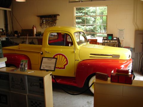 1993 Ford Taurus - A vintage yellow and red Ford F-series pickup truck, likely from the early 1950s, is displayed indoors with a prominent Shell logo on its s…