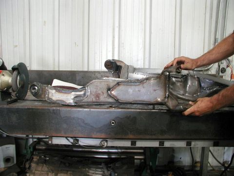 1980 Ford Bronco - A heavily modified suspension component is being worked on, with a grinder visible in the background.