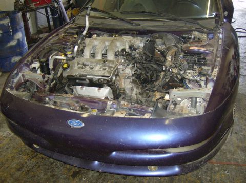 1996 Ford Probe - Engine bay of a 1996 Ford Probe, with the engine partially disassembled.