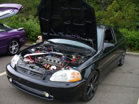 1991 Ford Probe - A black coupe with its hood open reveals the engine bay, parked next to a purple vehicle.