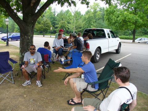 1991 Ford Probe - People gathered around a white pickup truck in a parking lot on a sunny day.