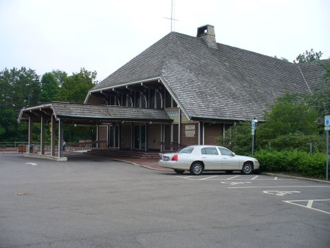 1991 Ford Probe - A white sedan is parked in front of a building with a distinctive, multi-layered roof structure.