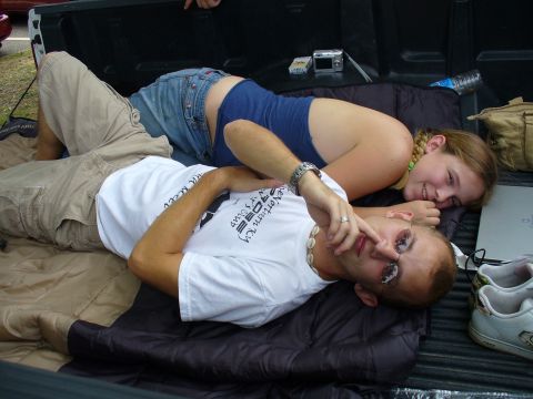 1991 Ford Probe - A couple relaxes in the back of a truck, with a camera and a water bottle visible.