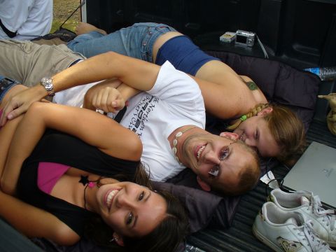 1991 Ford Probe - Friends relax in the bed of a pickup truck, with a camera and laptop nearby.