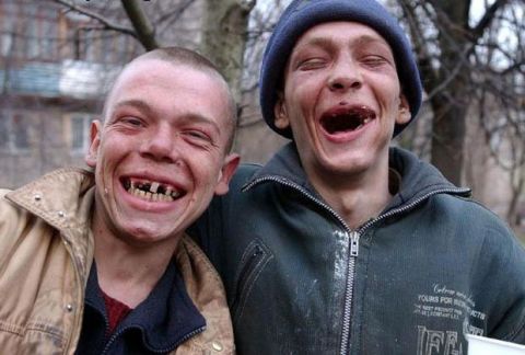 2005 Ford Excursion - Two men with missing teeth share a laugh outdoors, with a building and trees in the background.