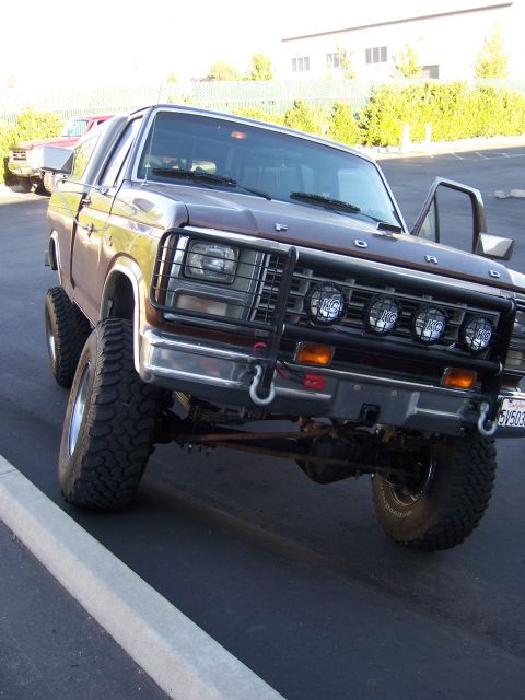 1991 Ford Bronco - This lifted Ford Bronco has a brush guard and auxiliary lights, with another vehicle in the background.