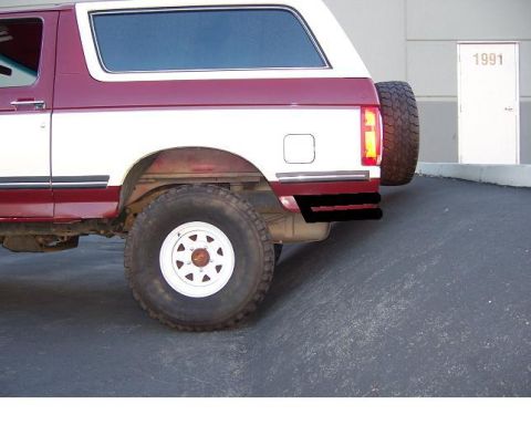 1991 Ford Bronco - The rear section of a two-tone Ford Bronco is shown, with a spare tire and a custom bumper. A door labeled '1991' is in the background.