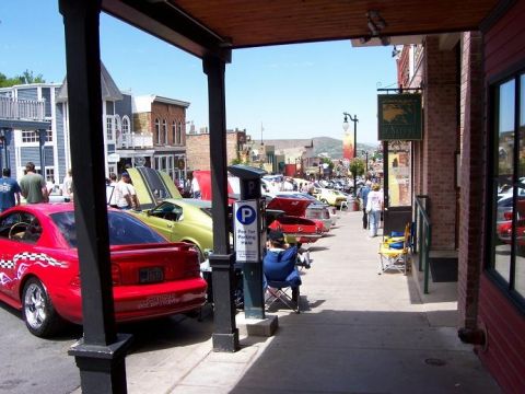1972 Ford Ranchero - Cars parked along a street in a town, with people walking on the sidewalk.